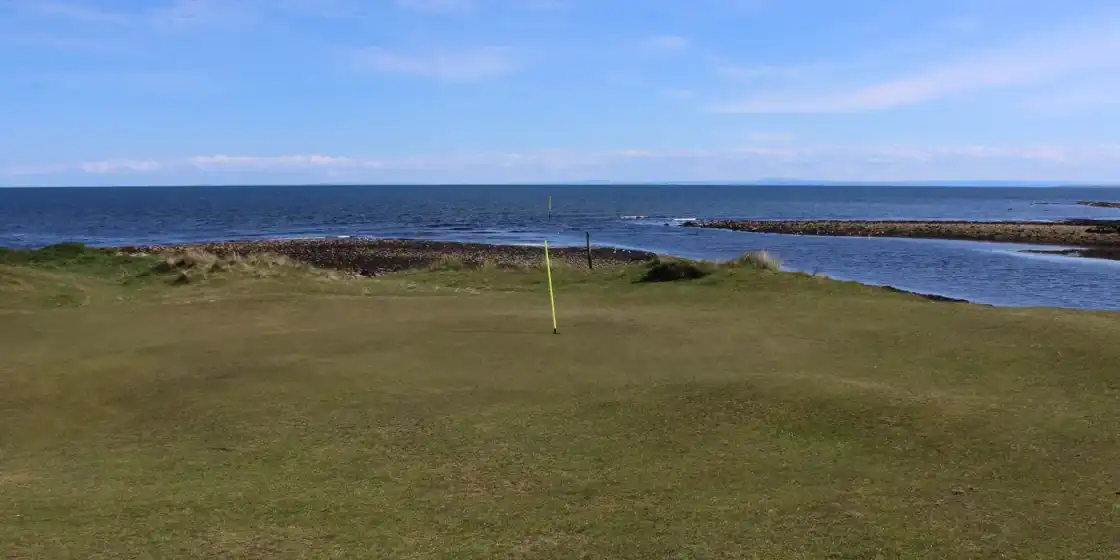 A green at Brora Golf Club above the shore and the North Sea