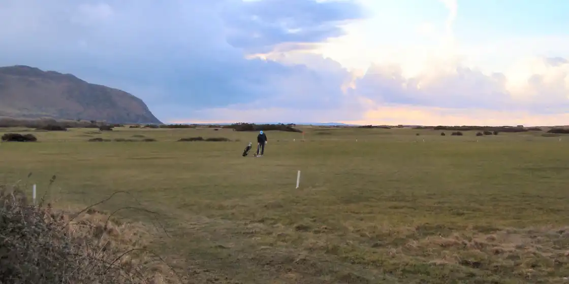 The links at Conwy Golf Club at dusk, with the Great Orme headland behind
