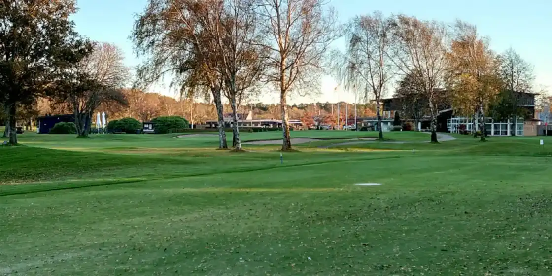 A green and bunkers below the clubhouse at Halmstad Golfklubb in Tylösand