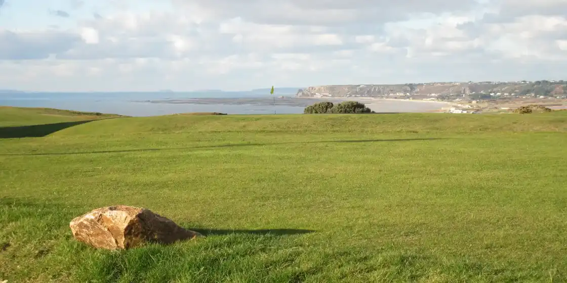 A green at La Moye Golf Club above St Ouen's Bay on Jersey's west coast