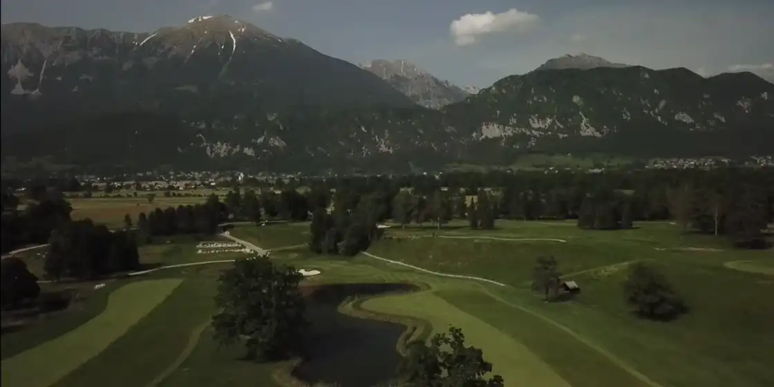 Aerial view of Royal Bled Golf with a pond and fairways below the Karawanks mountains