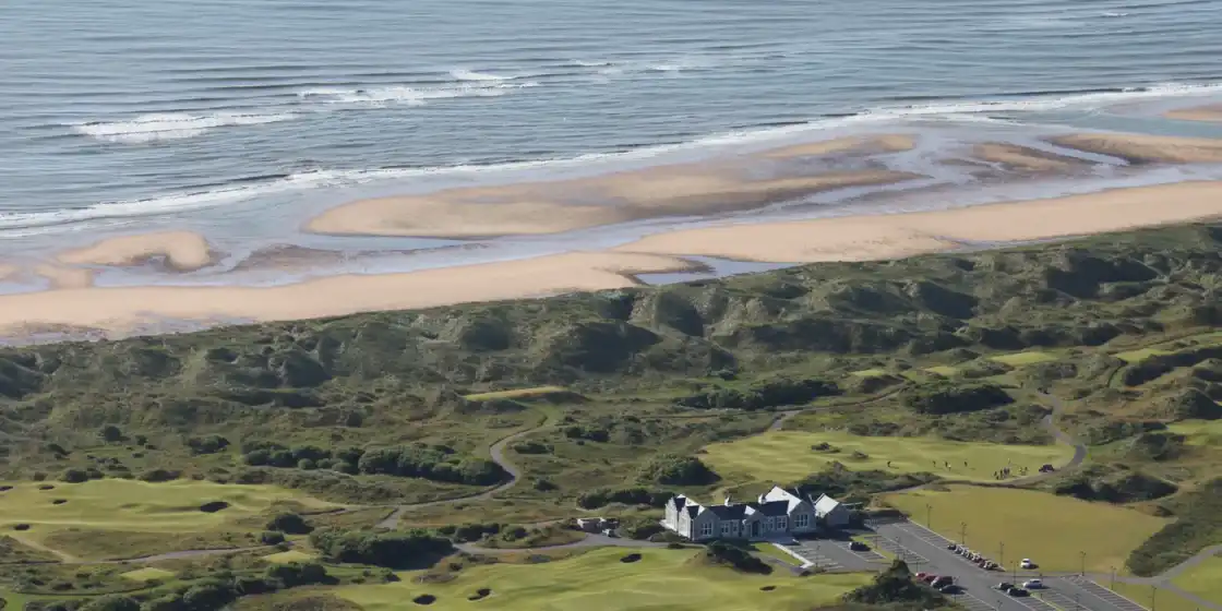 Aerial view of the dunes, fairways and clubhouse at Trump International Golf Links Scotland